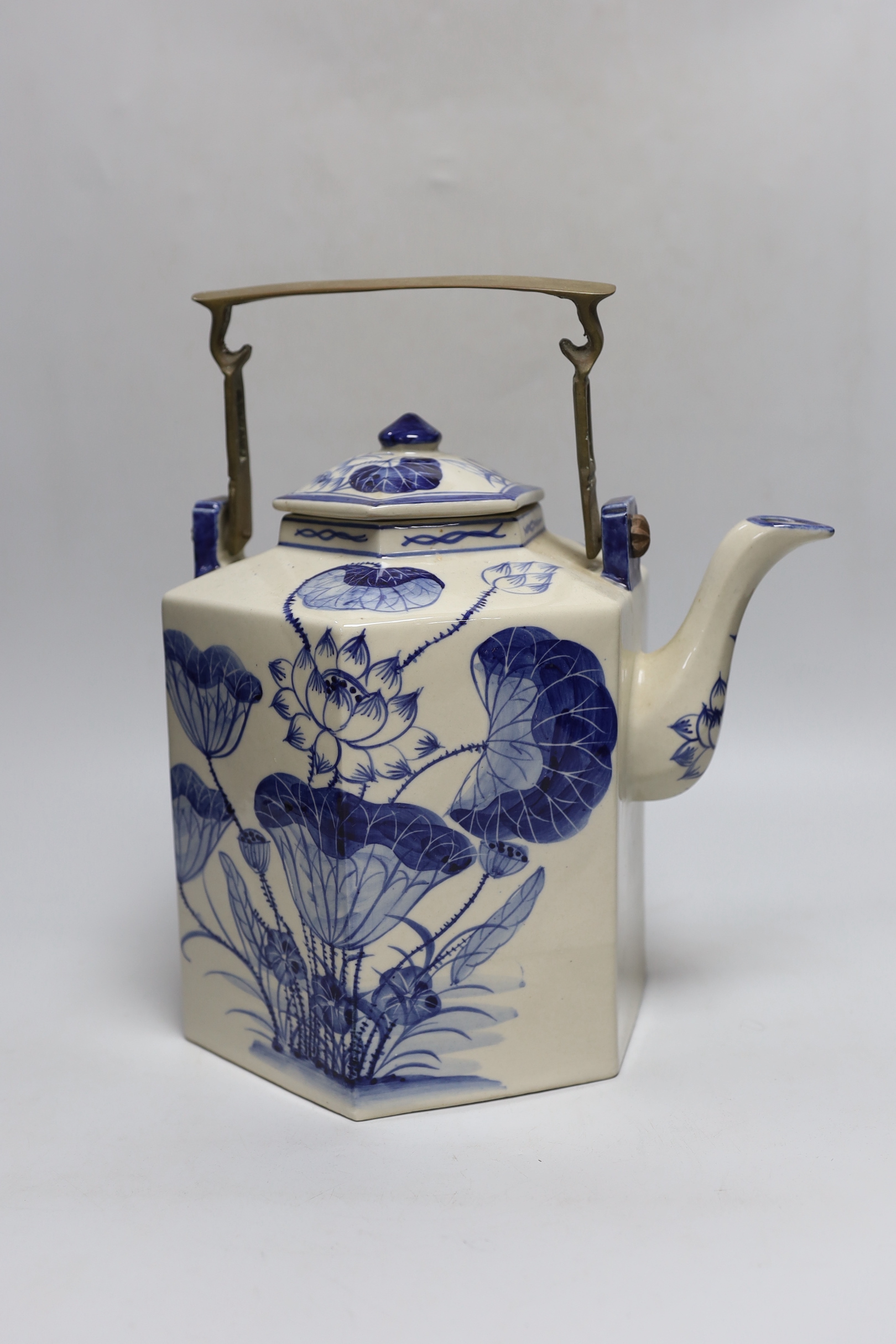 A Chinese blue and white oversized hexagonal teapot, with brass fitted handle and floral decoration, 30cm tall